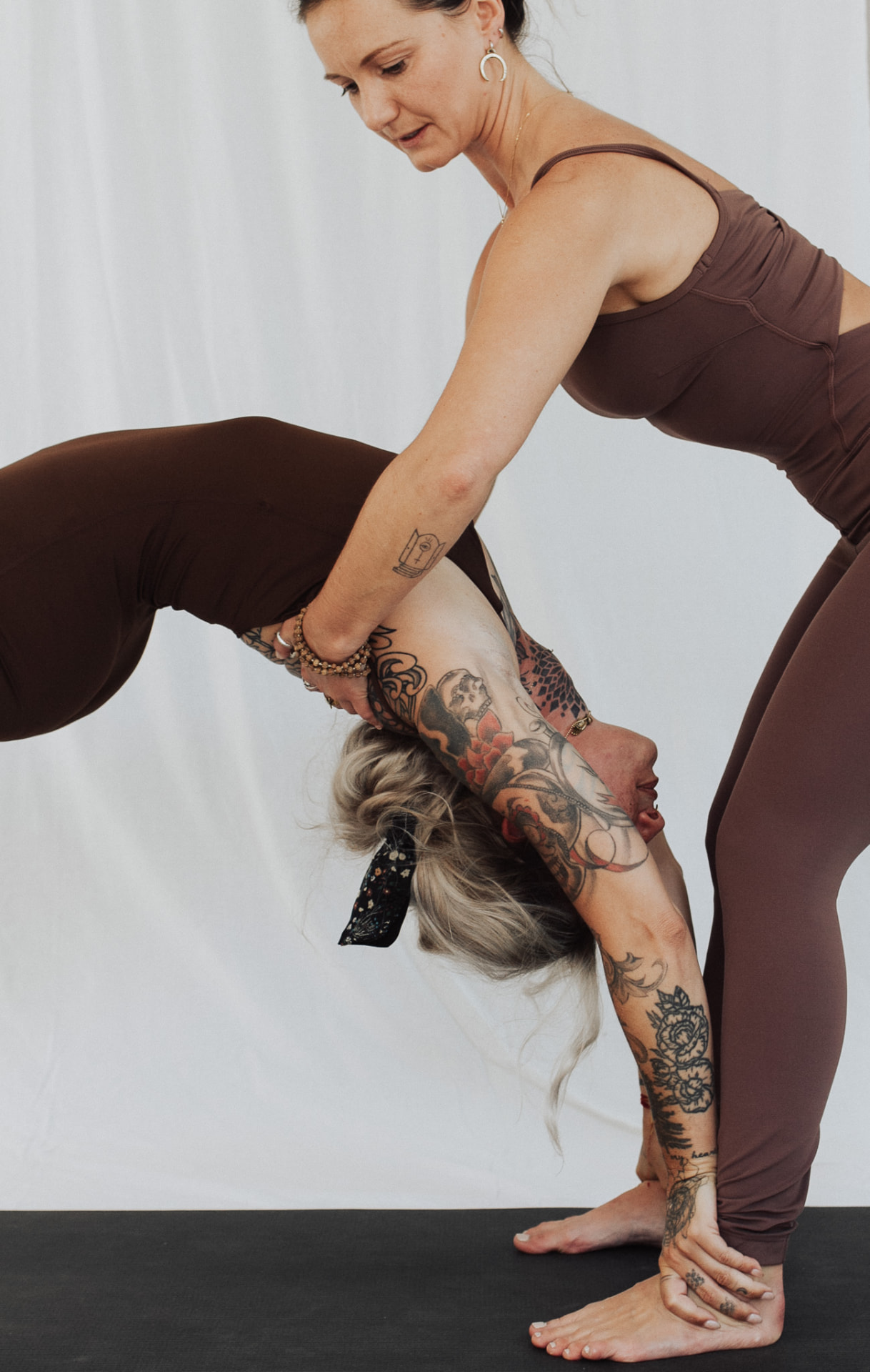 Izabella adjusting a client's forward bend during a teaching session