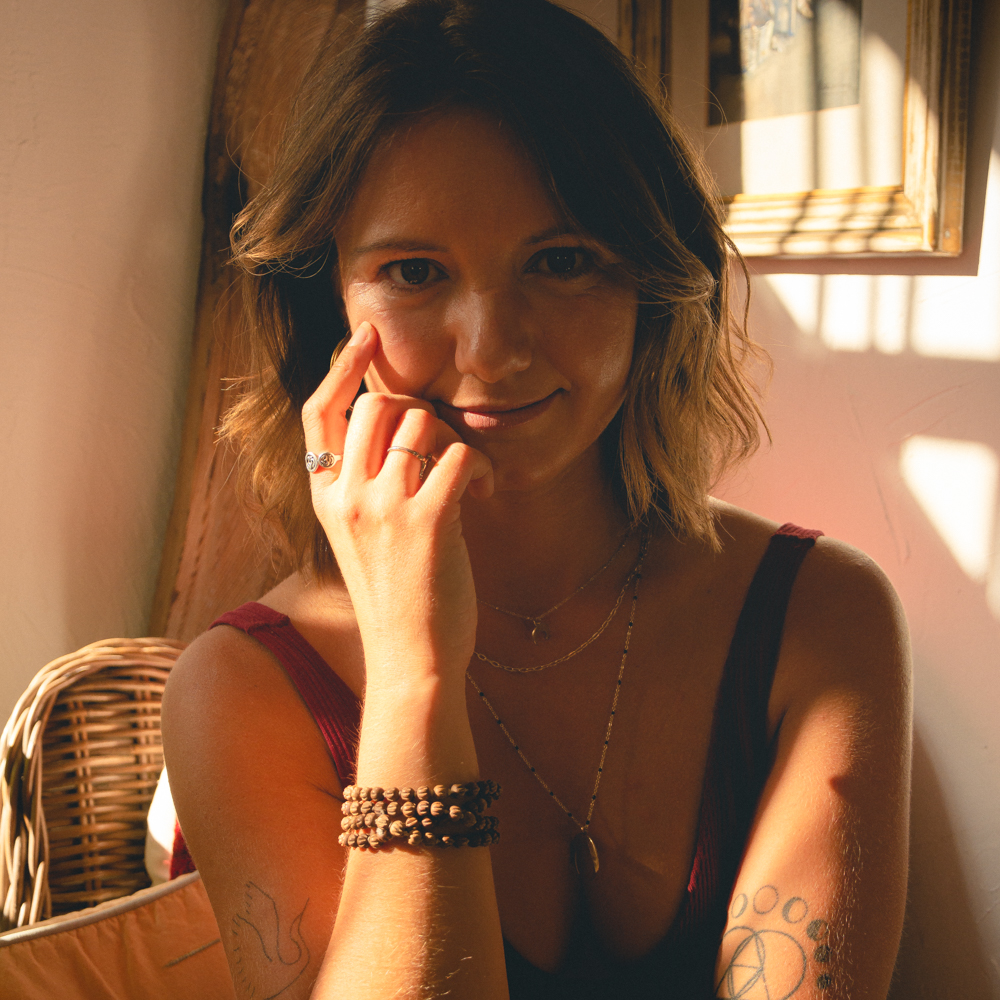Izabella Soko in warm sunlight, resting her hand near her cheek